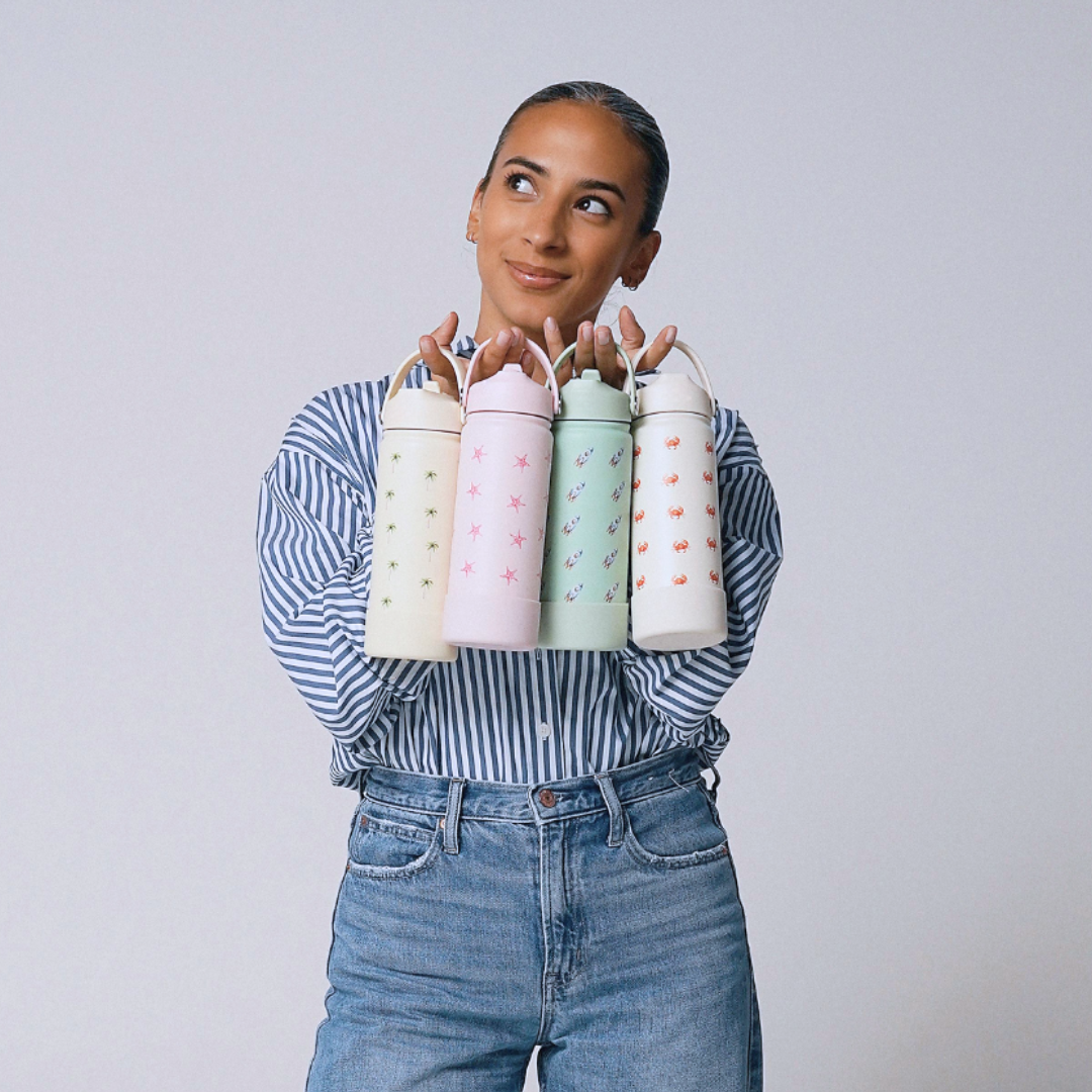 Sabriya Piccolo holding four colorful Piccolo Co water bottles against a plain background